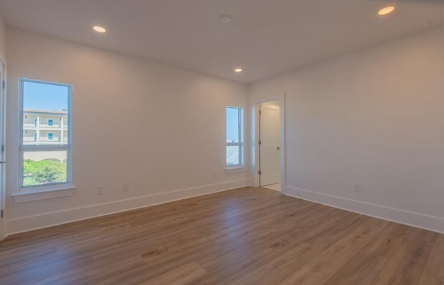 empty room with a healthy amount of sunlight and dark hardwood / wood-style flooring