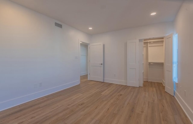 unfurnished bedroom featuring a closet and light wood-type flooring