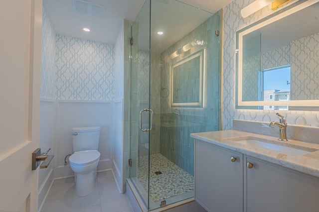 bathroom featuring a shower with door, tile floors, vanity, and toilet