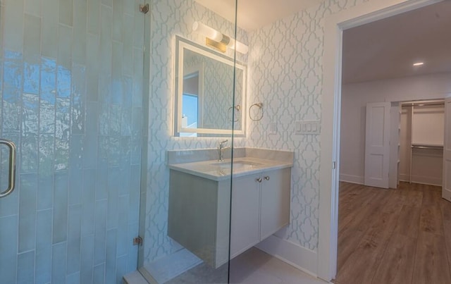 bathroom featuring a shower with shower door, wood-type flooring, and large vanity