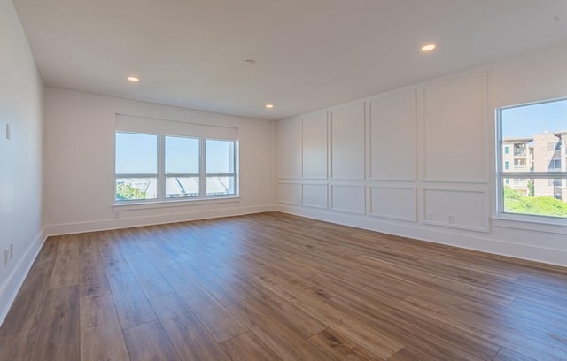 unfurnished room featuring a wealth of natural light and dark hardwood / wood-style flooring