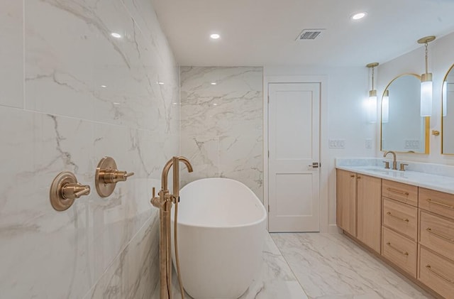 bathroom with tile walls, a tub, vanity, and tile floors