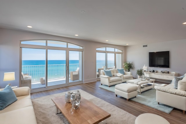 living room with a water view and hardwood / wood-style flooring