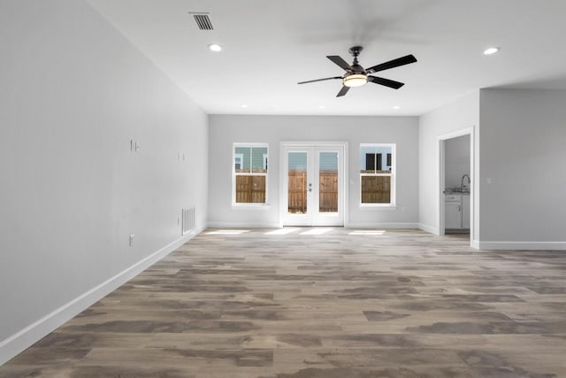 unfurnished living room featuring wood-type flooring, ceiling fan, and french doors