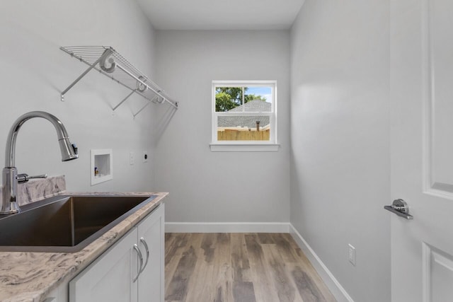 washroom with light hardwood / wood-style floors, electric dryer hookup, cabinets, sink, and washer hookup