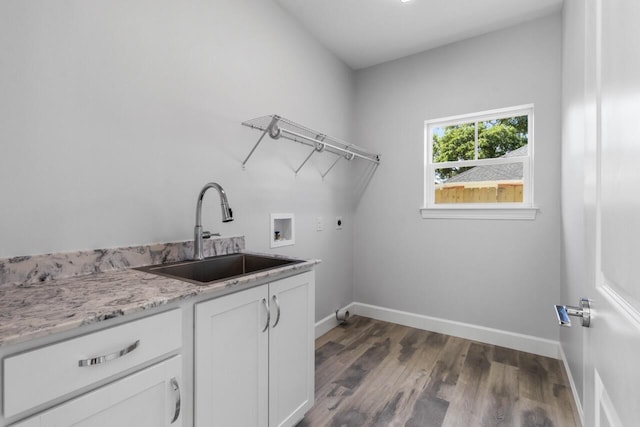 clothes washing area with dark hardwood / wood-style flooring, electric dryer hookup, cabinets, sink, and hookup for a washing machine