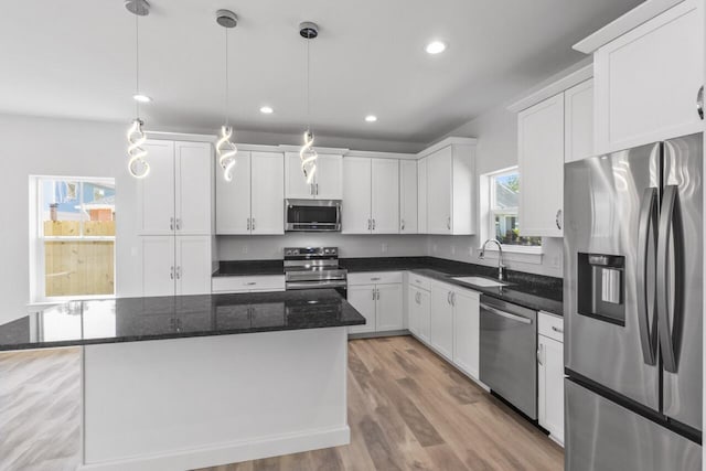 kitchen featuring white cabinets, a wealth of natural light, stainless steel appliances, and a kitchen island