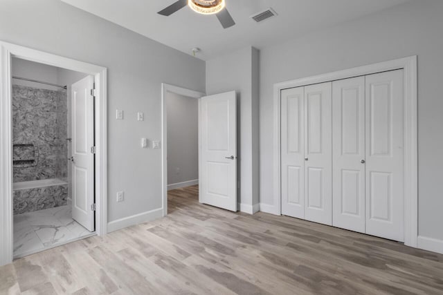 unfurnished bedroom featuring connected bathroom, a closet, light hardwood / wood-style floors, and ceiling fan