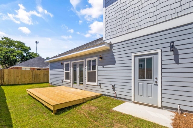 back of house with a yard, french doors, and a wooden deck