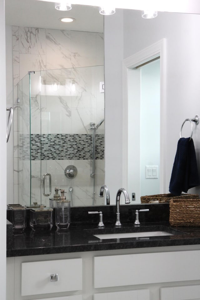 bathroom with a shower with door and vanity