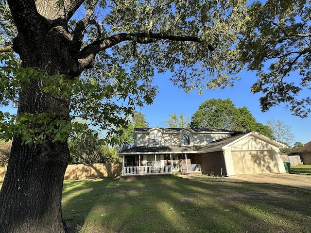 view of front facade with a garage, covered porch, and a front yard