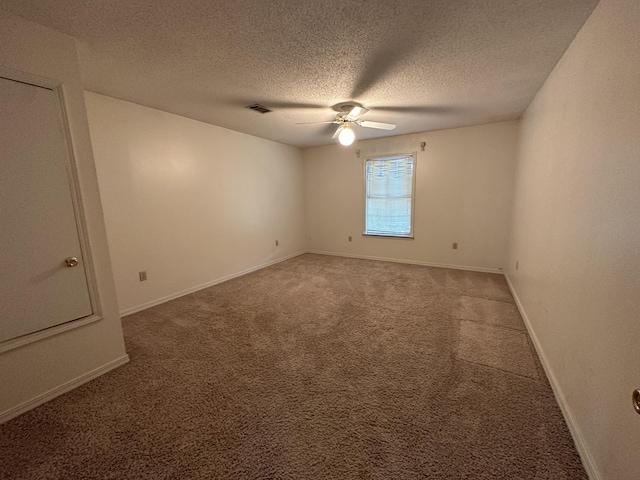 carpeted spare room featuring ceiling fan and a textured ceiling