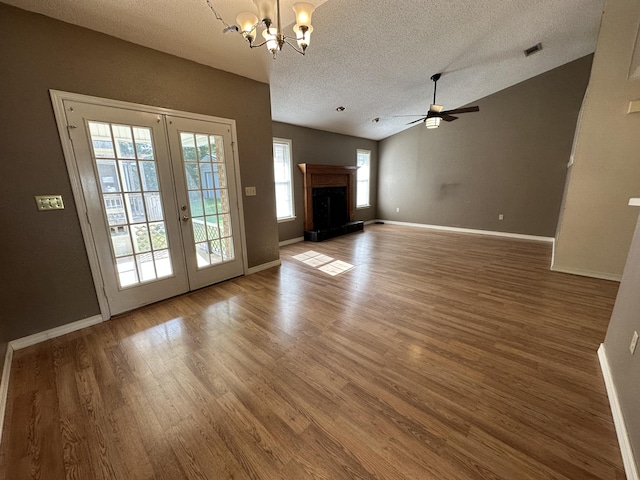 unfurnished living room featuring plenty of natural light, dark hardwood / wood-style flooring, and lofted ceiling