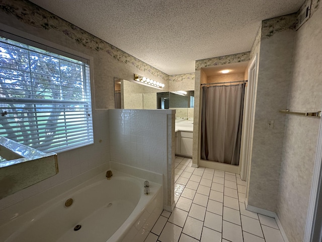 bathroom with a bath to relax in, vanity, tile floors, and a textured ceiling