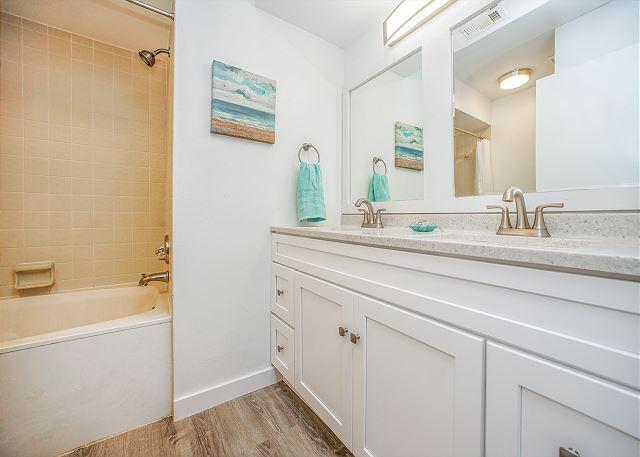 bathroom featuring hardwood / wood-style floors, vanity, and shower / bath combo