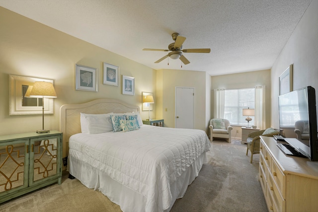 carpeted bedroom with ceiling fan and a textured ceiling