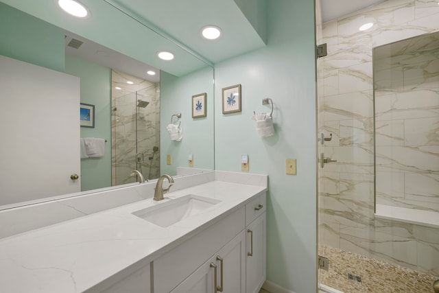 bathroom featuring oversized vanity and a shower with shower door