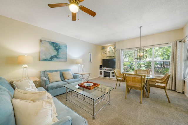 living room featuring ceiling fan with notable chandelier, a textured ceiling, and carpet floors