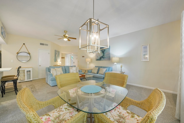 carpeted dining space featuring ceiling fan with notable chandelier