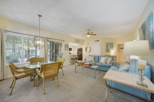 dining area with ceiling fan with notable chandelier and carpet