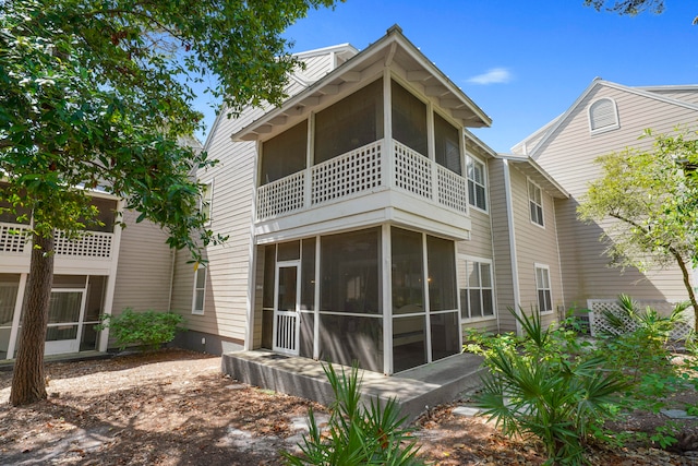 back of house with a balcony and a sunroom