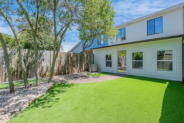 view of yard with central AC and a patio