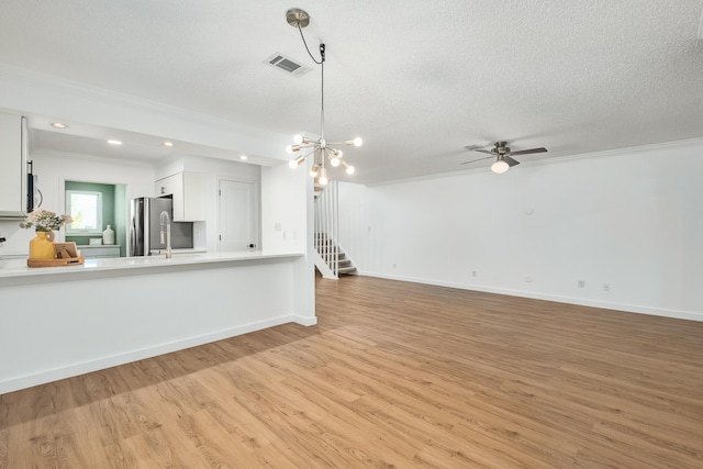 kitchen featuring light hardwood / wood-style flooring, stainless steel fridge, white cabinetry, and crown molding