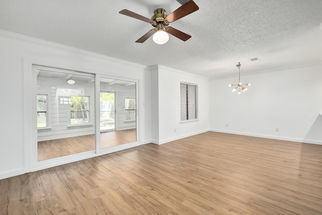 spare room with ceiling fan with notable chandelier, a textured ceiling, crown molding, and light wood-type flooring