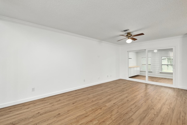 empty room with light hardwood / wood-style flooring, crown molding, ceiling fan, and a textured ceiling