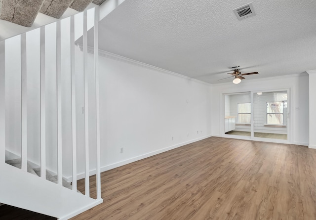 unfurnished living room featuring hardwood / wood-style flooring, crown molding, ceiling fan, and a textured ceiling