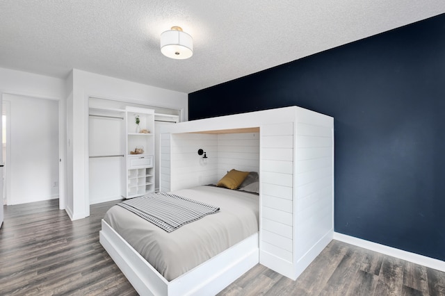 bedroom with dark hardwood / wood-style floors and a textured ceiling