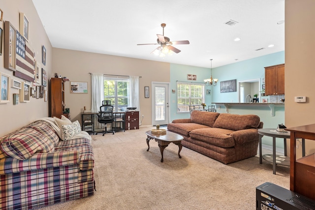 living room with light colored carpet and ceiling fan with notable chandelier