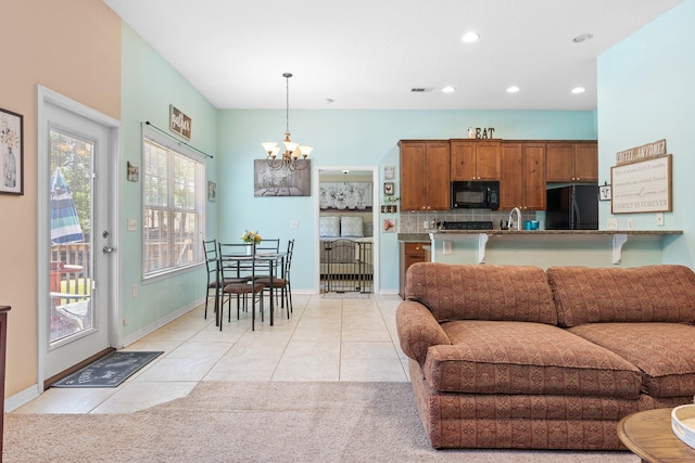 carpeted living room with sink and a chandelier