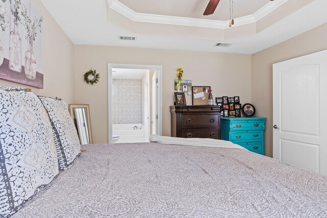 carpeted bedroom featuring ceiling fan, crown molding, a raised ceiling, and ensuite bathroom