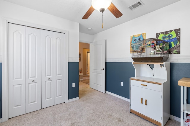 bedroom featuring light carpet, a closet, and ceiling fan