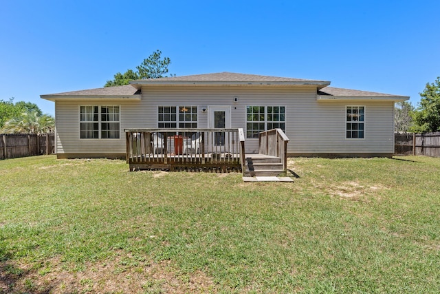 rear view of house featuring a wooden deck and a lawn