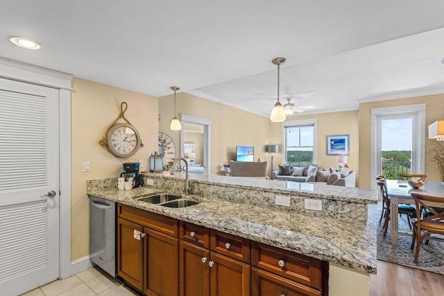 kitchen featuring ceiling fan, sink, dishwasher, decorative light fixtures, and light stone countertops