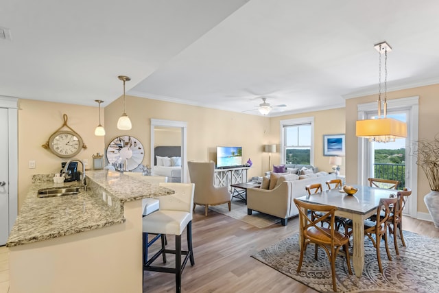 dining area with sink, ceiling fan, crown molding, and hardwood / wood-style flooring