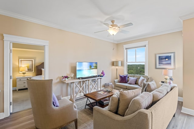 living room with light hardwood / wood-style flooring, ceiling fan, and ornamental molding