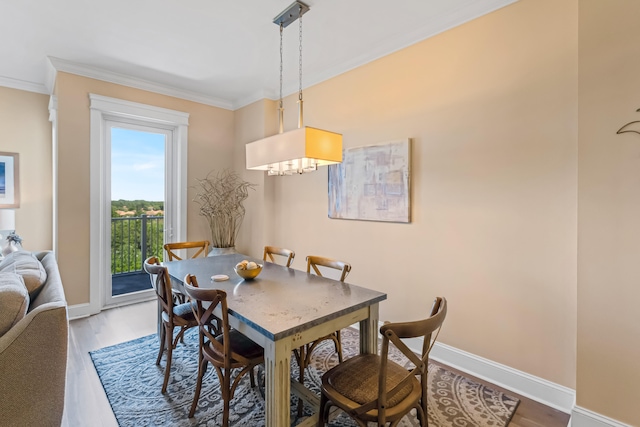 dining area with dark hardwood / wood-style floors, crown molding, and a chandelier