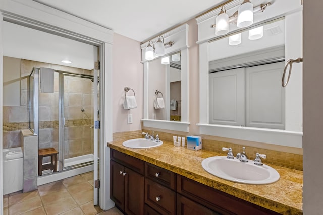 bathroom featuring a shower with door, double vanity, and tile flooring