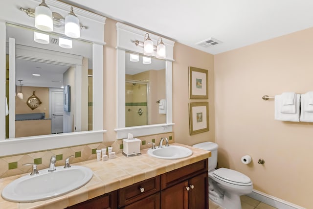 bathroom with tile floors, oversized vanity, toilet, and double sink