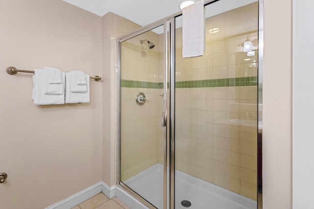 bathroom featuring a shower with door and tile flooring