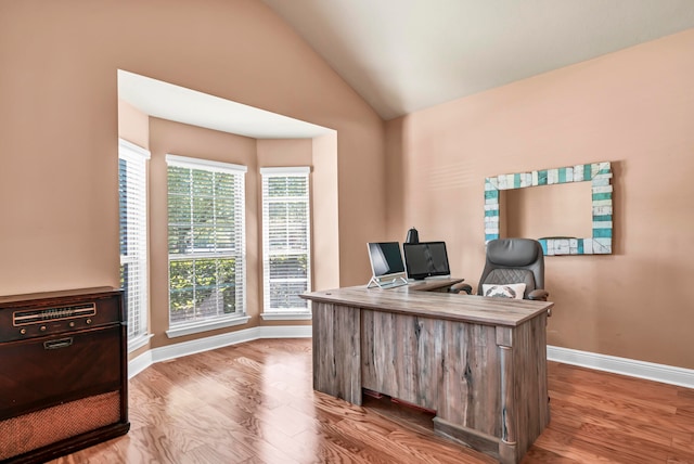 office space with lofted ceiling, plenty of natural light, and light hardwood / wood-style floors