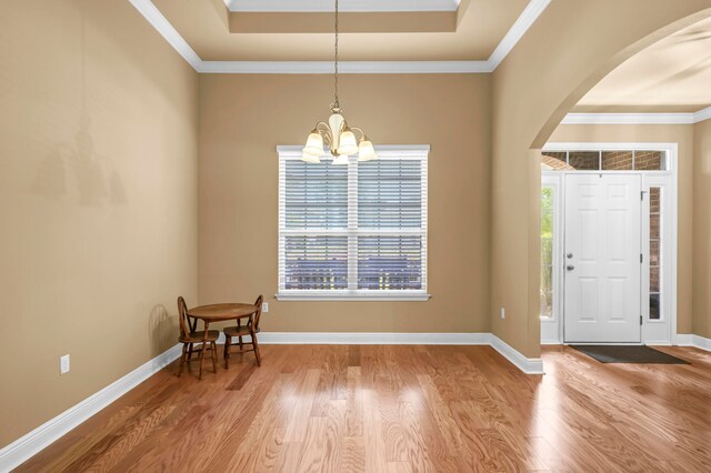 entrance foyer with light hardwood / wood-style flooring, an inviting chandelier, and ornamental molding