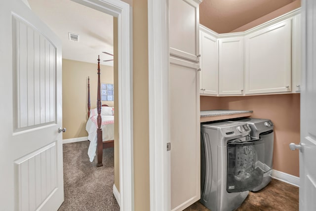 washroom featuring dark carpet, cabinets, and washer and dryer