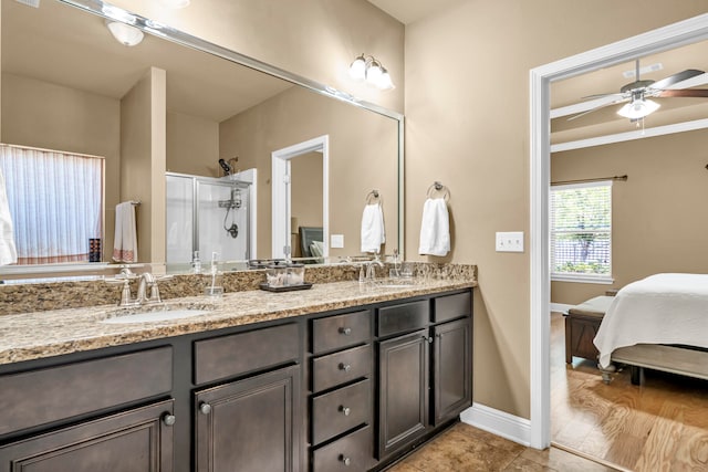 bathroom featuring vanity with extensive cabinet space, wood-type flooring, ornamental molding, dual sinks, and ceiling fan