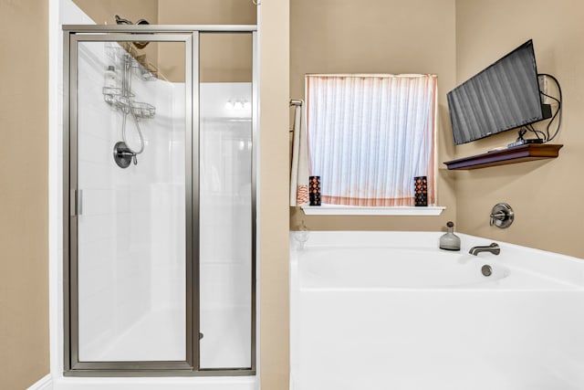 bathroom featuring independent shower and bath