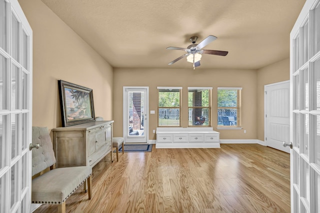 unfurnished room featuring french doors, ceiling fan, and light wood-type flooring