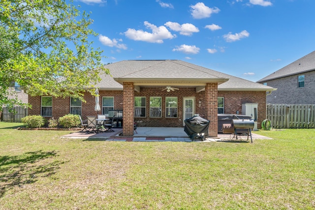 rear view of house with a patio area, a yard, and ceiling fan